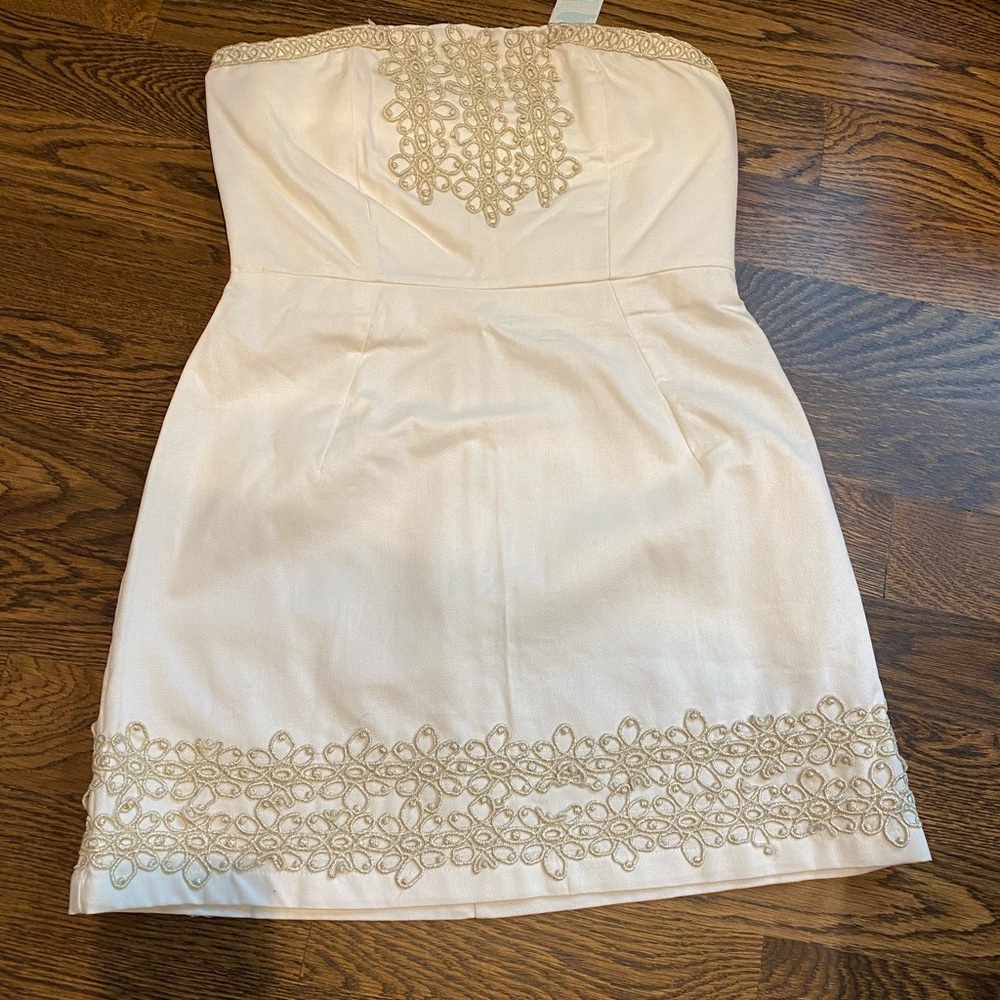 Beautiful strapless ivory dress and gold detail.